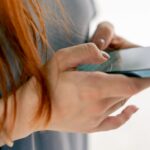 close-up of female hands holding smartphone texting with a girlfriend or a friend in messenger