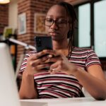 Freelancer sending text messages on smartphone