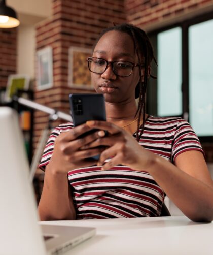 Freelancer sending text messages on smartphone