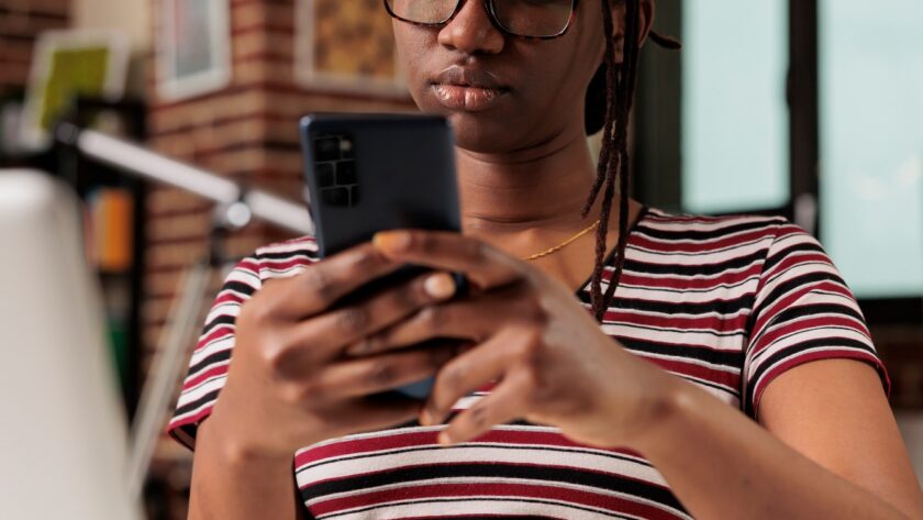 Freelancer sending text messages on smartphone