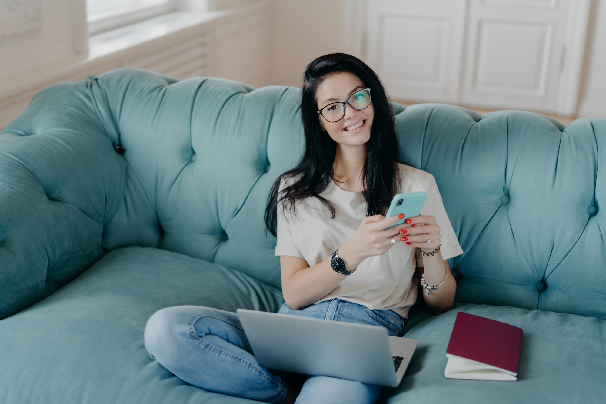 Beautiful woman in transparent glasses and casual clothes, sends files, browses social networks