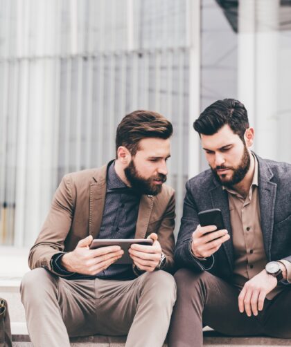 Two casual businessmen using tablet