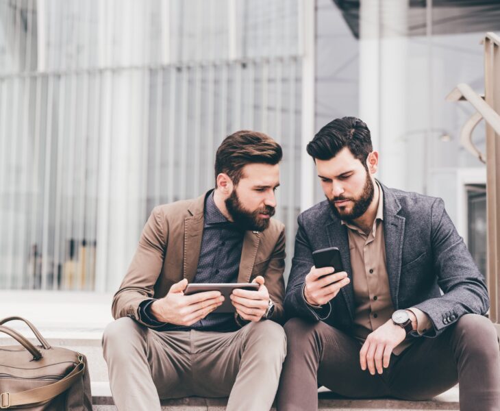 Two casual businessmen using tablet