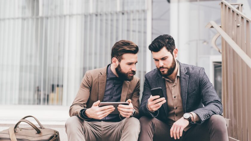 Two casual businessmen using tablet