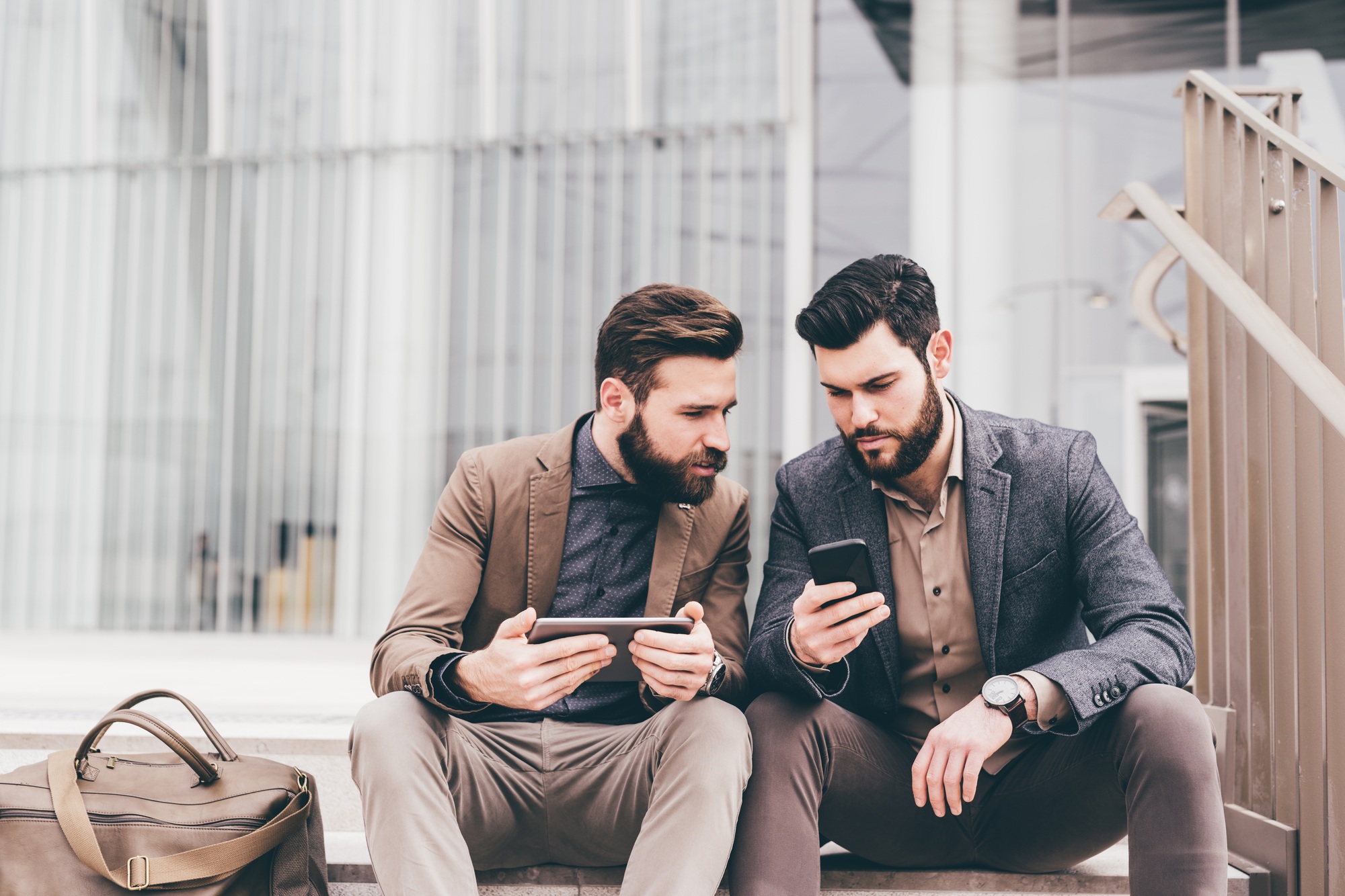 Two casual businessmen using tablet