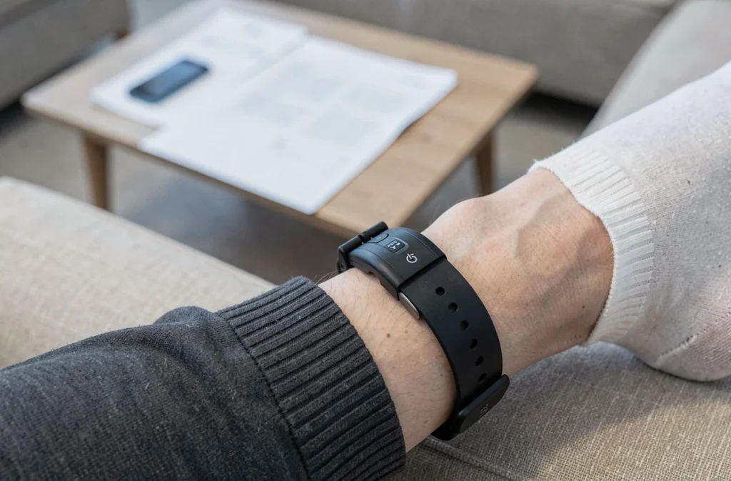 Gros plan d'un bracelet électronique de surveillance porté à la cheville dans un contexte de détention à domicile